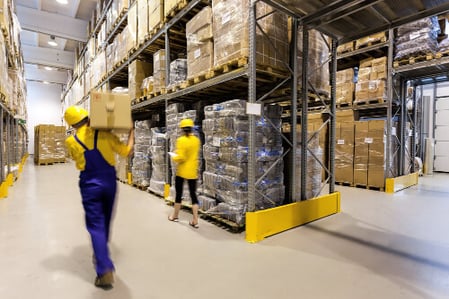 Warehouse worker with box and manager controlling products x 500-2